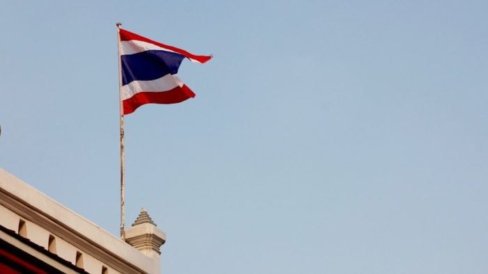 Un drapeau thaïlandais flottant au-dessus d'un bâtiment.