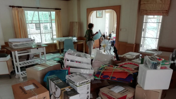 A room full of packed moving boxes and furniture.