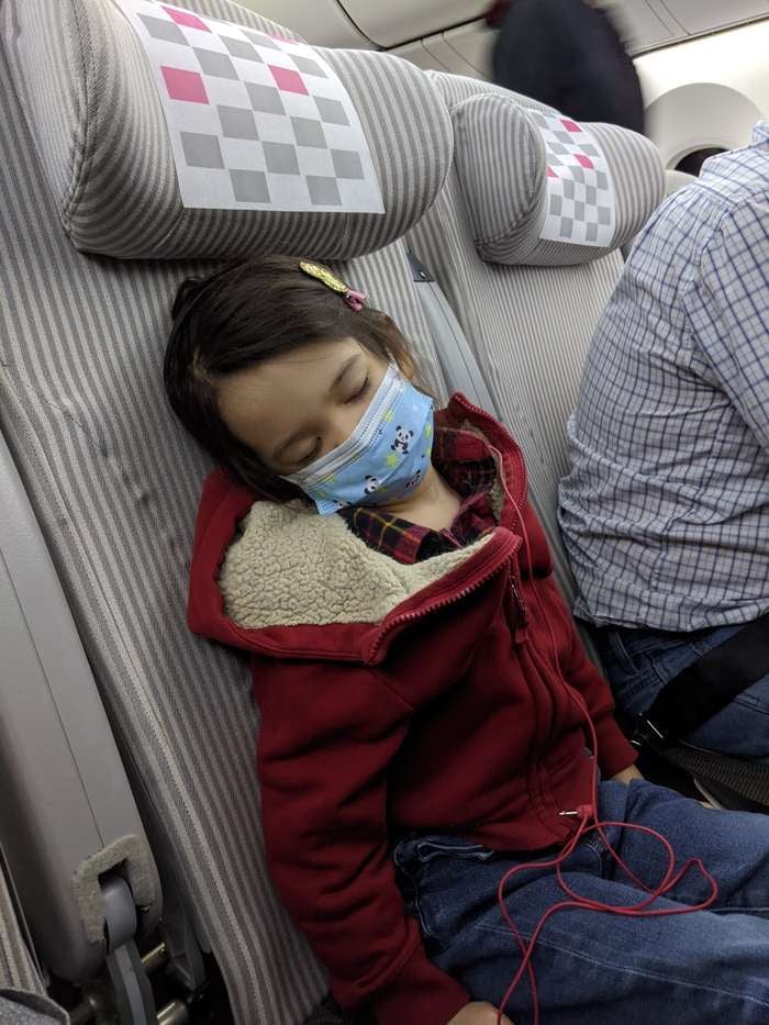 Child sleeping in seat on airplane
