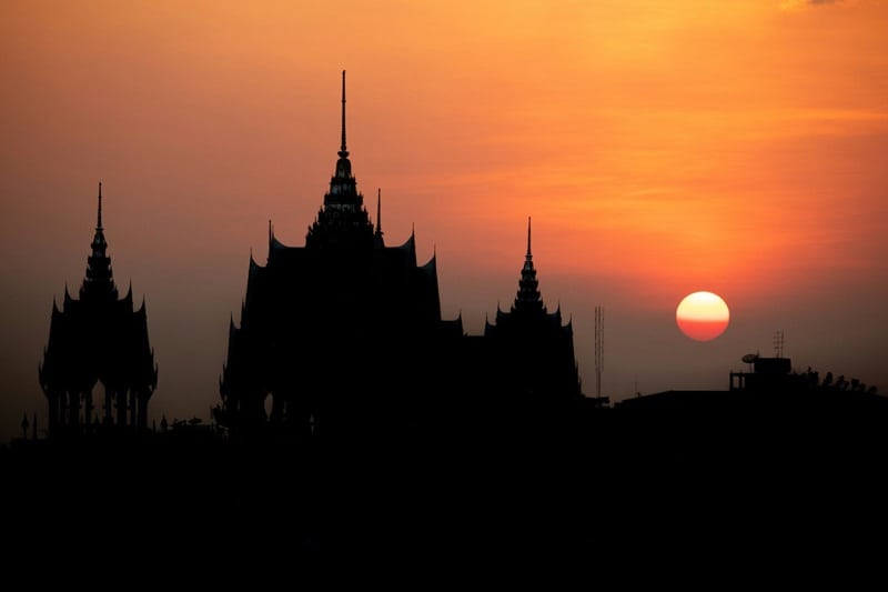 A temple in Thailand with an orange sunset
