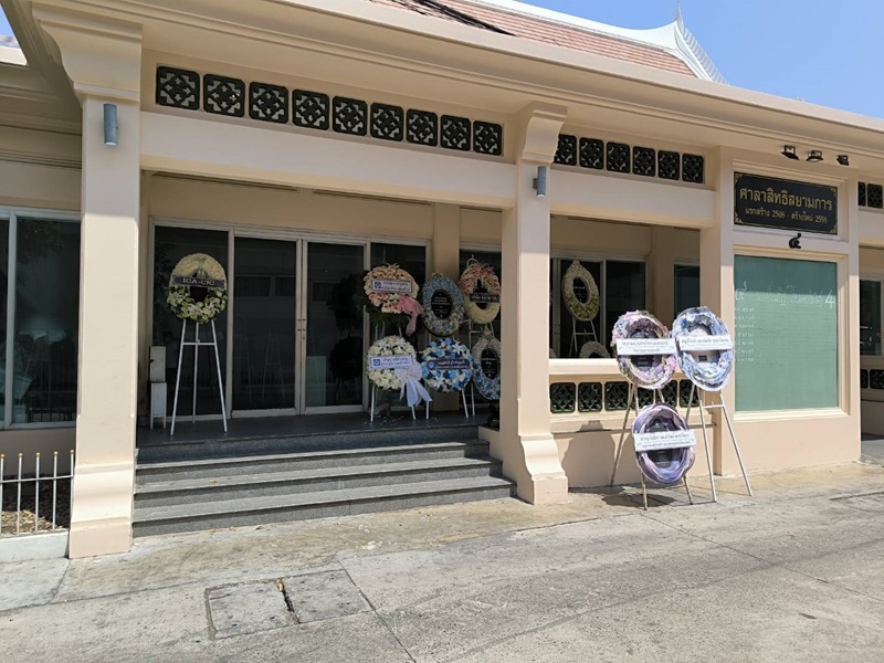 Funeral wreaths standing outside a building in a temple where mourners can purchase them.