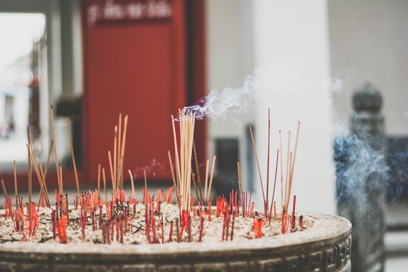 A pot of incense burn at a temple in Thailand to honor the deceased.