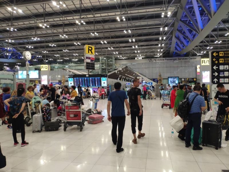 Travelers with luggage in the departure hall at Suvarnabhumi Airport, Bangkok