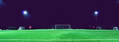 A football stadium under floodlights at night