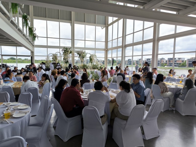 Guests seated at round tables at a Thai wedding reception