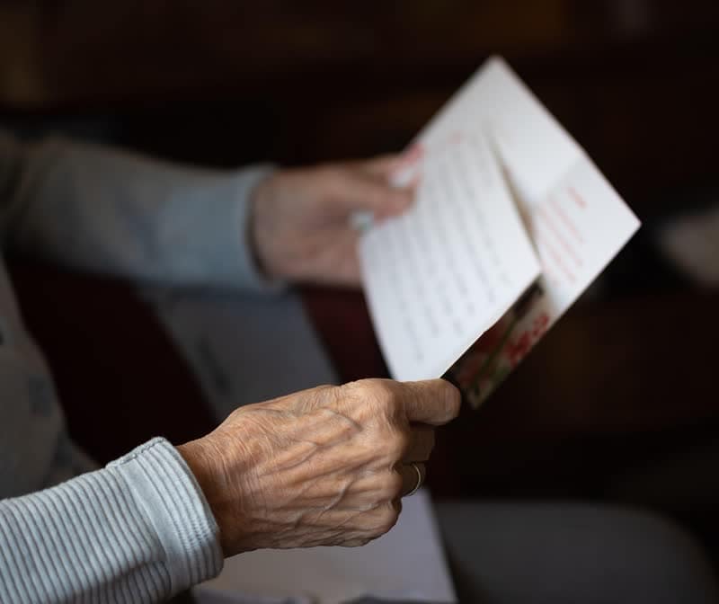 Elderly hands holding and reading a letter