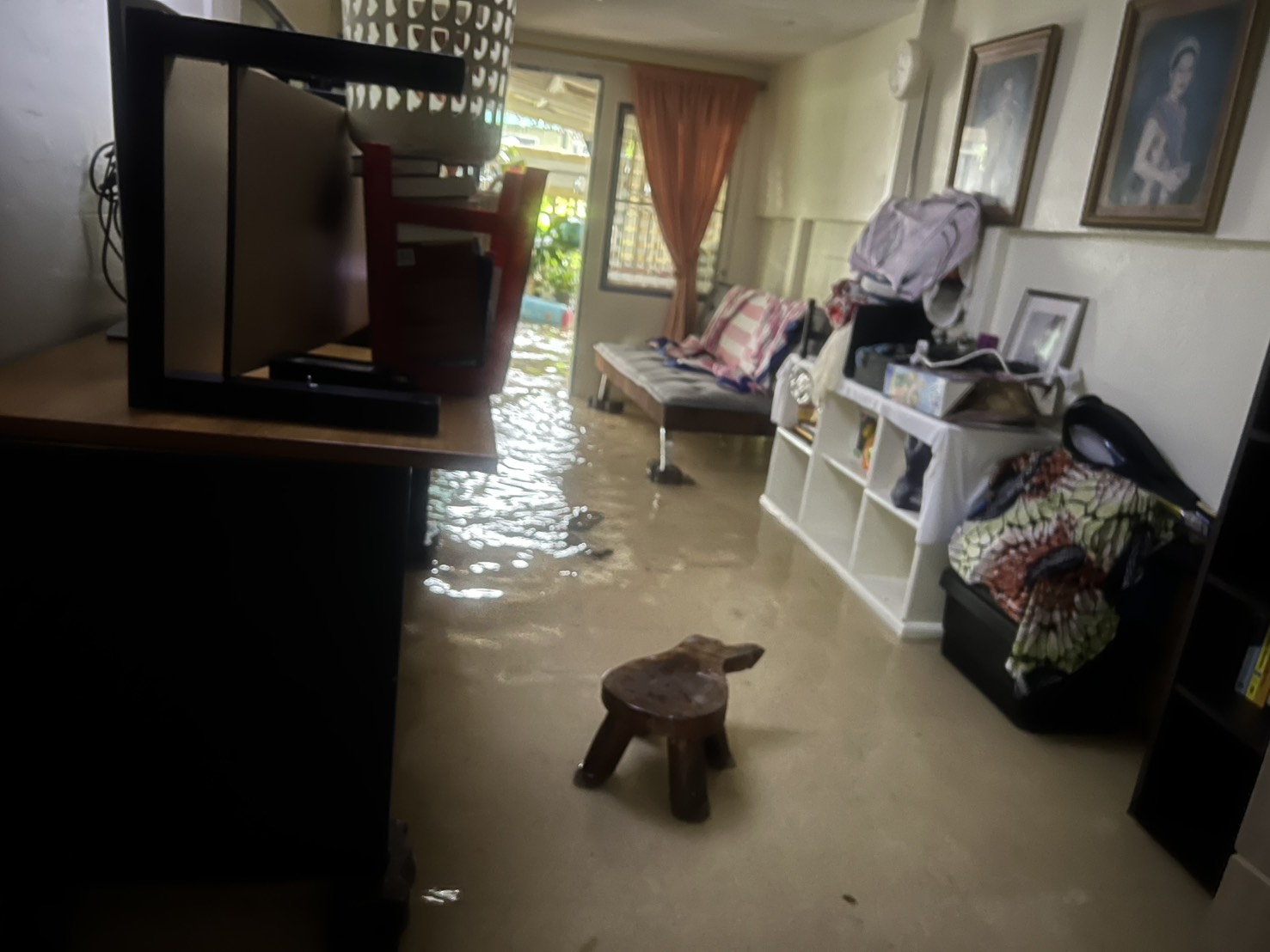Flooded living room inside a Bangkok home with wet furniture