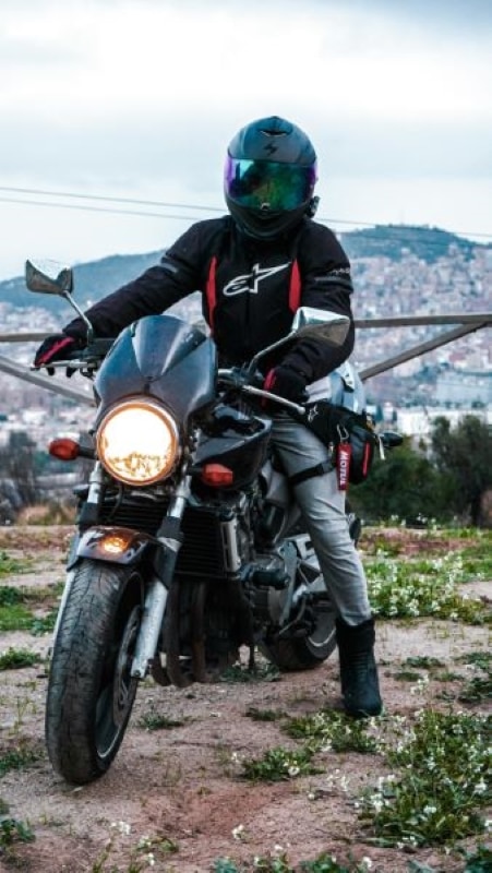 motorcycle rider in full protective gear with helmet, jacket, gloves and boots in Thailand