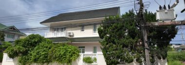 Detached family house behind a white wall in a housing estate in Rayong, Thailand