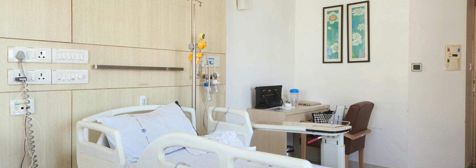 Private hospital room with an adjustable bed and visitor chair
