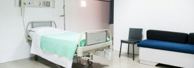 Private hospital room with bed and sofa