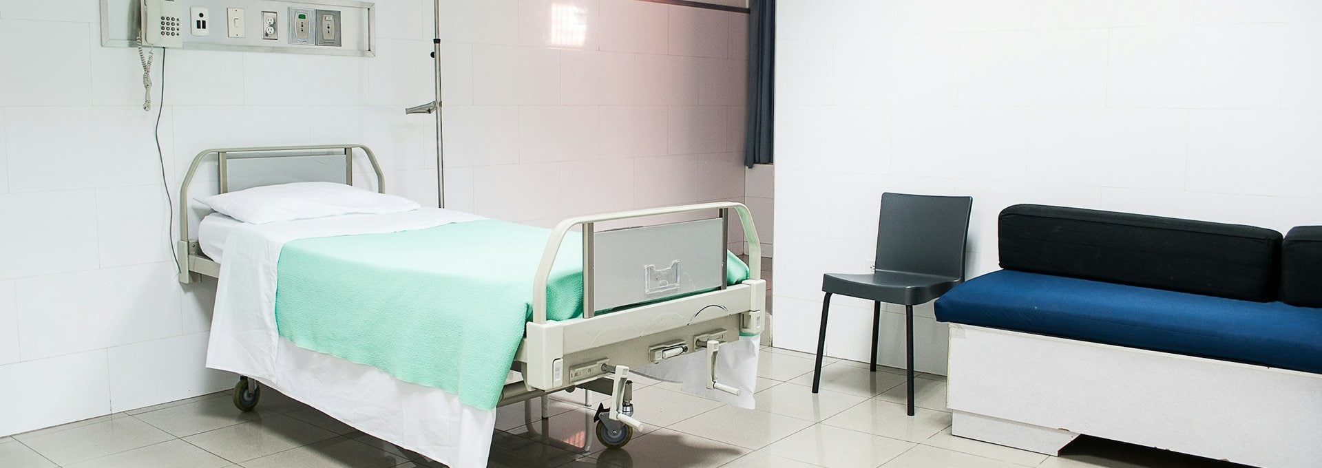 Private hospital room with bed and sofa