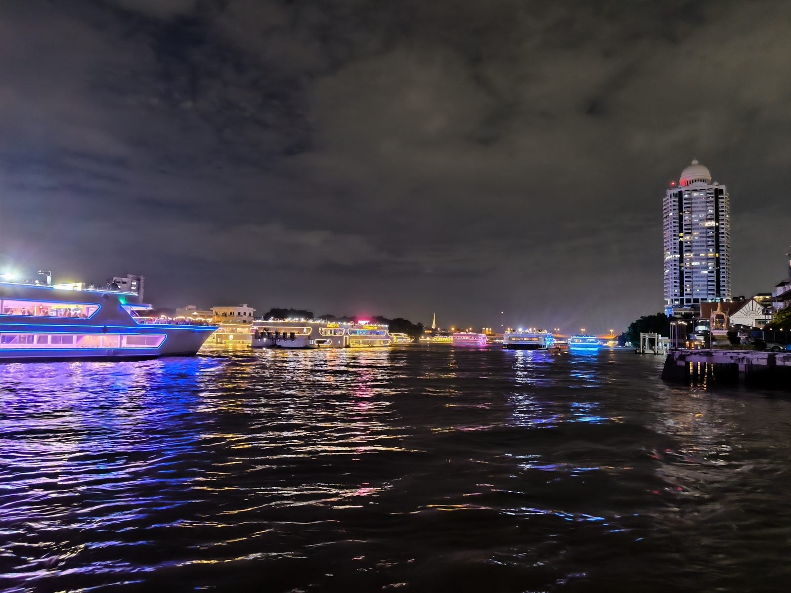 Dinner cruise boats lit up on the Chao Phraya River at night