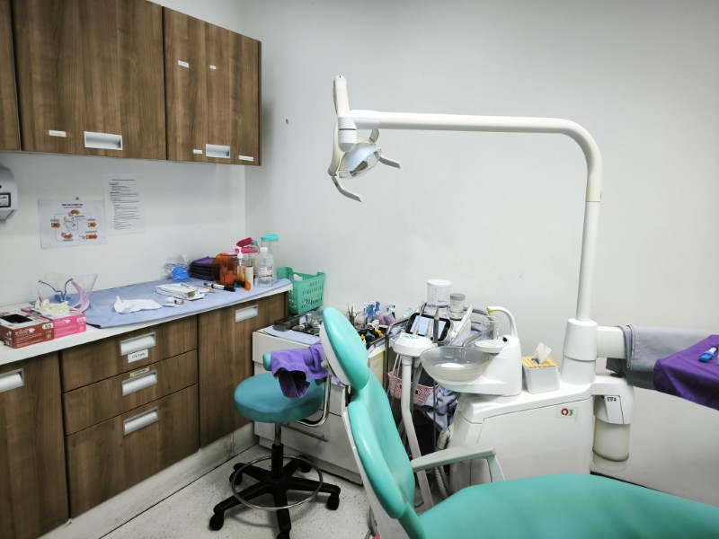 Dental treatment room with a teal chair at a Bangkok clinic