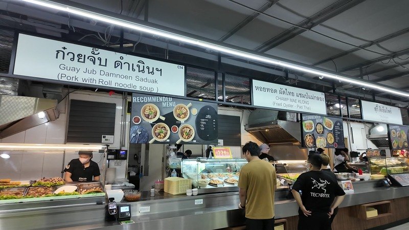 Customers ordering at noodle and pad thai stalls in the MBK Center food court in Bangkok