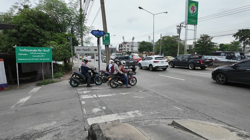 Motorbikes waiting at a main-road junction near Rom Klao in Min Buri, Bangkok