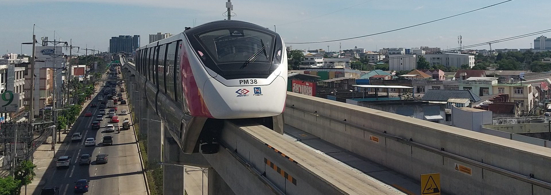 An MRT Pink Line monorail on its elevated track above traffic on Ram Inthra Road, Bangkok