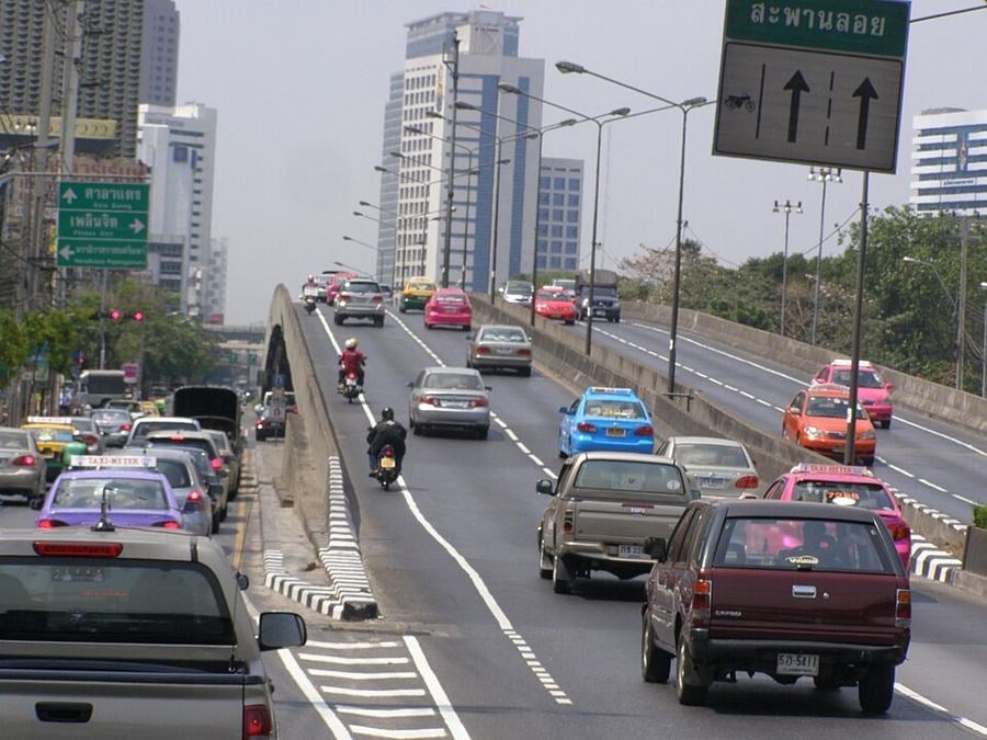 Traffic on a Rama IV Road flyover near Lumphini in Bangkok, with signs for Sala Daeng and Phloen Chit