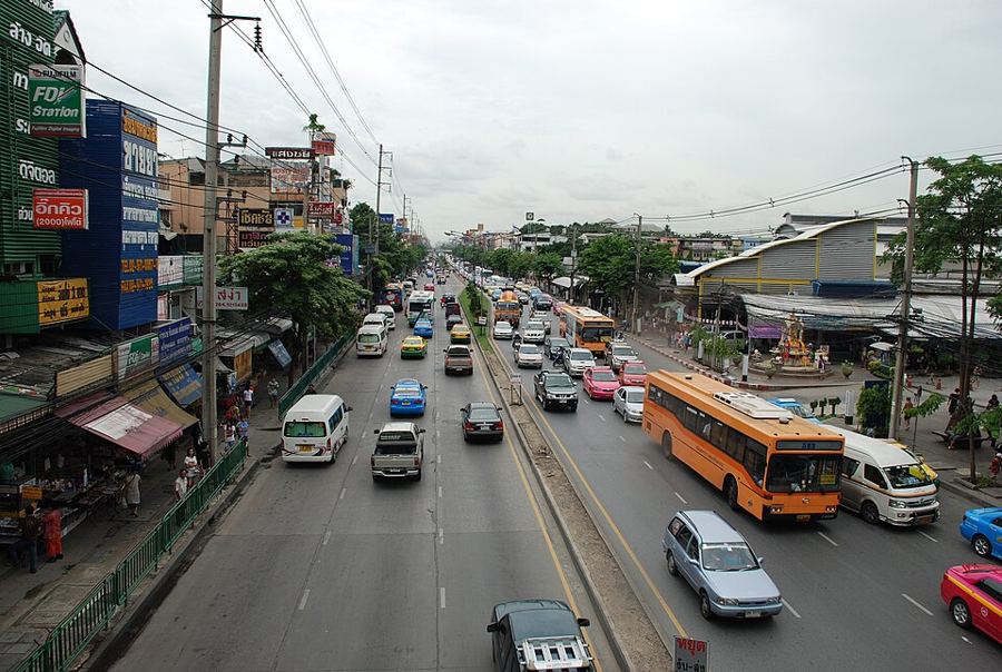 Phahon Yothin Road at Saphan Mai seen from an overpass, with buses, vans and roadside shops