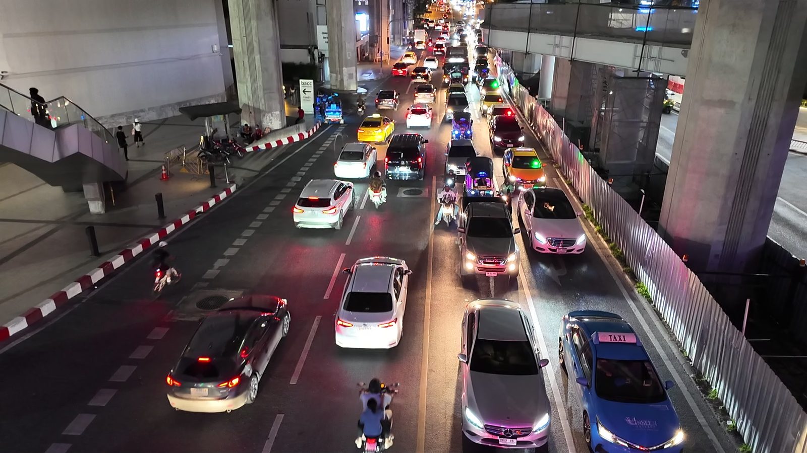 Tuk-tuks lined up under the BTS track near Siam station at night