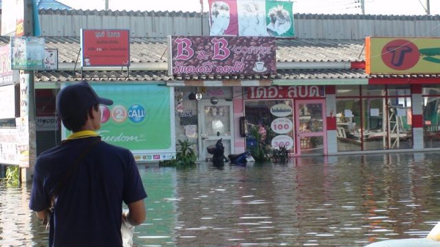 A man wading through flooded streets.