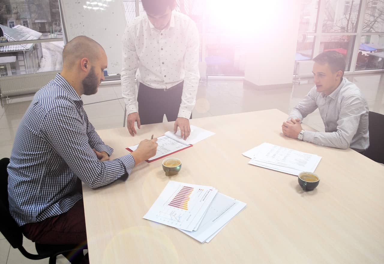 Two people going through company paperwork at a meeting table
